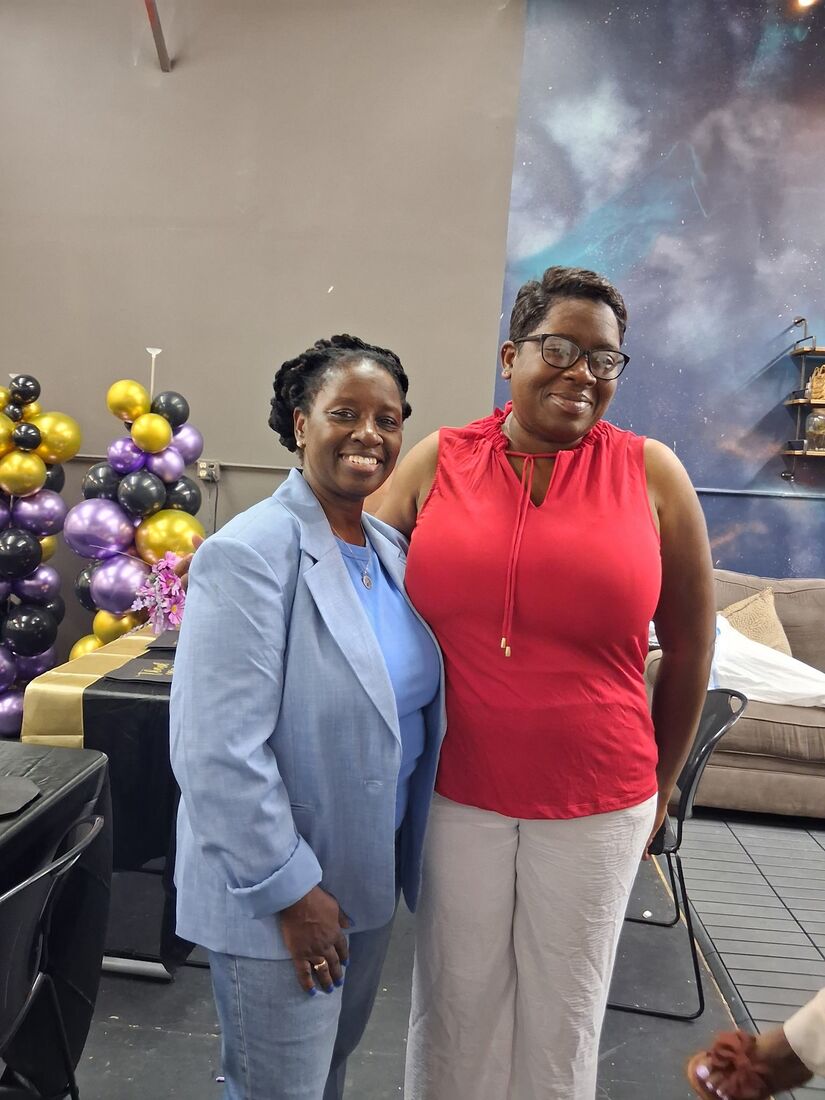 Wander Franklin with a guest in front of purple and gold balloons
